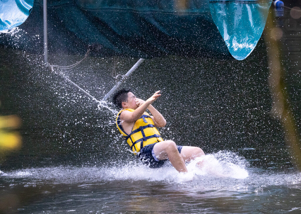 Boy diving into lake at summer camp
