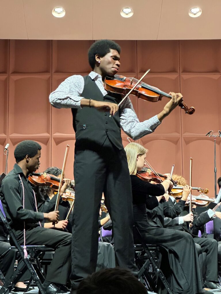 Solo violinist performed at the front of the stage during a concert